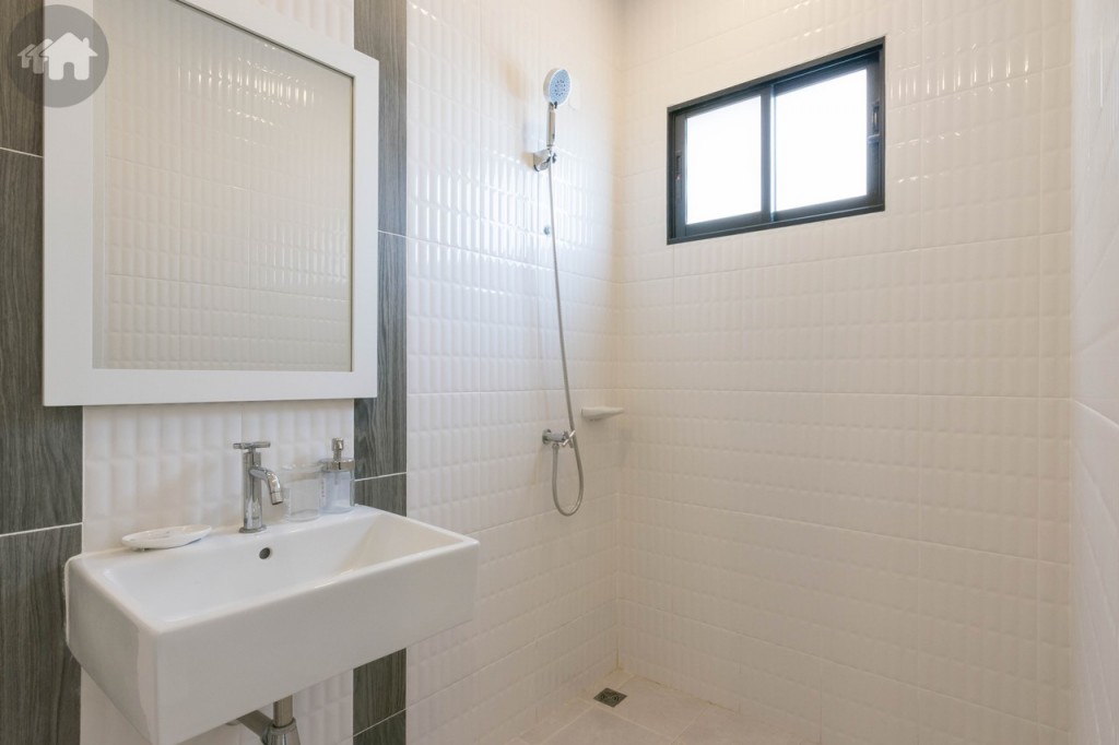 ห้องน้ำชั้นล่างอุปกรณ์ครบครัน พื้นห้องน้ำดร็อปจากพื้นห้องประมาณ 7 เซนติเมตร พื้นที่อาบน้ำมีขอบกั้นสูงประมาณ 7 เซนติเมตร