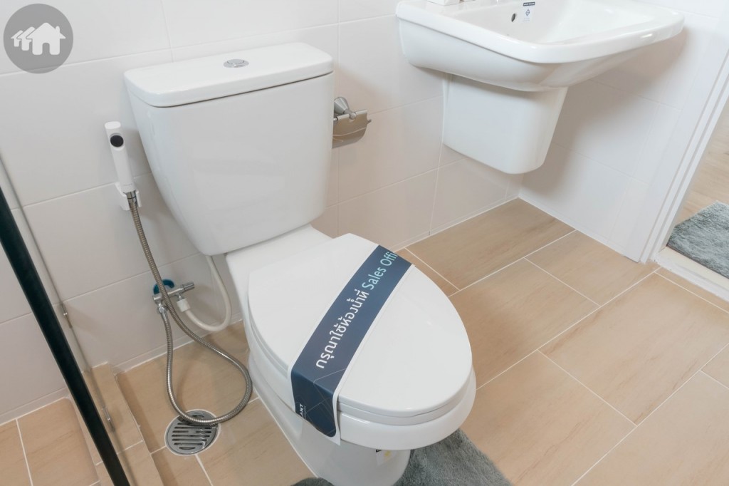 โถสุขภัณฑ์ของ Kohler พร้อมที่ใส่กระดาษชำระ และสายฉีดชำระ