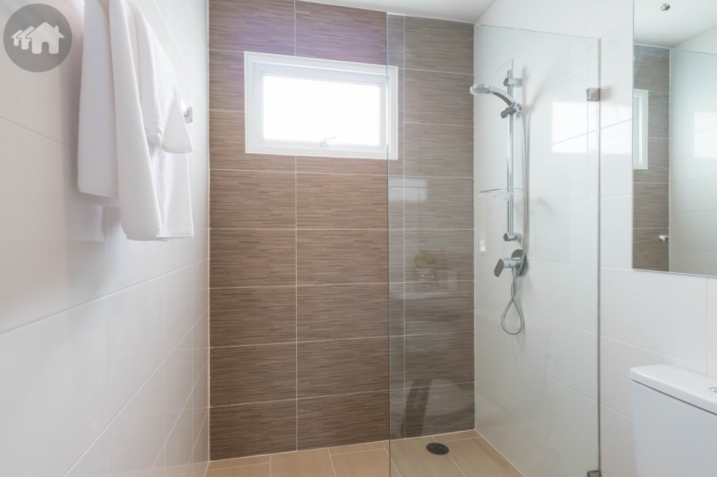 พื้นที่อาบน้ำกั้นเป็นสัดส่วนด้วยกระจกเทมเปอร์ มีขอบกั้นน้ำไหลมาส่วนอื่นของห้องน้ำสูงประมาณ 5 เซนติเมตร