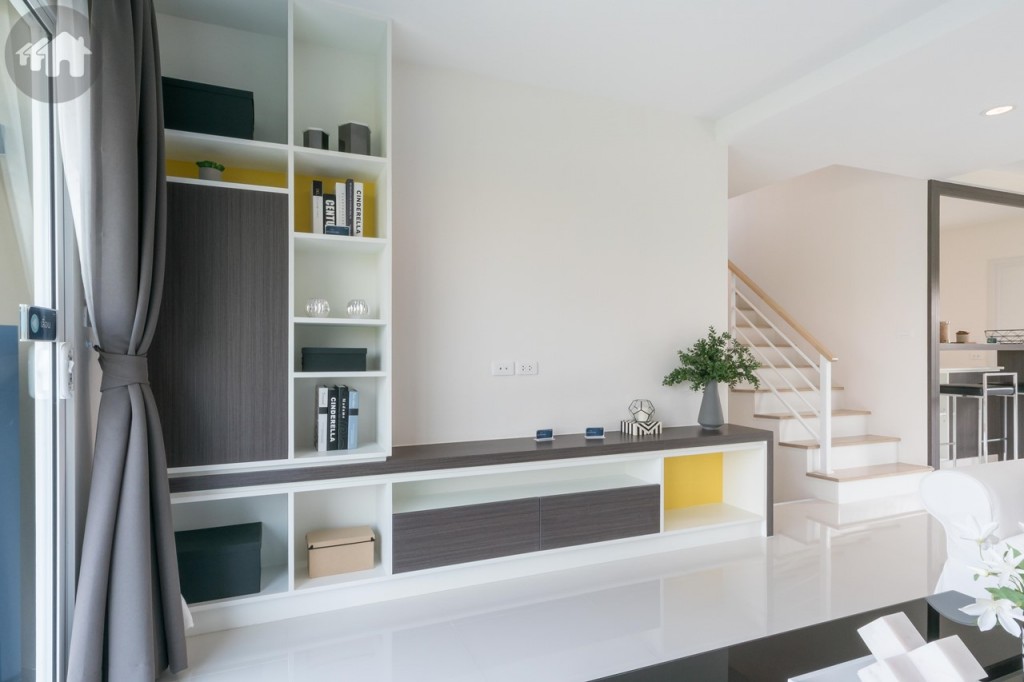 ฝั่งตรงข้ามตกแต่งเป็นชั้นวางโทรทัศน์ ห่างจากโซฟาประมาณ 2.50 เมตร