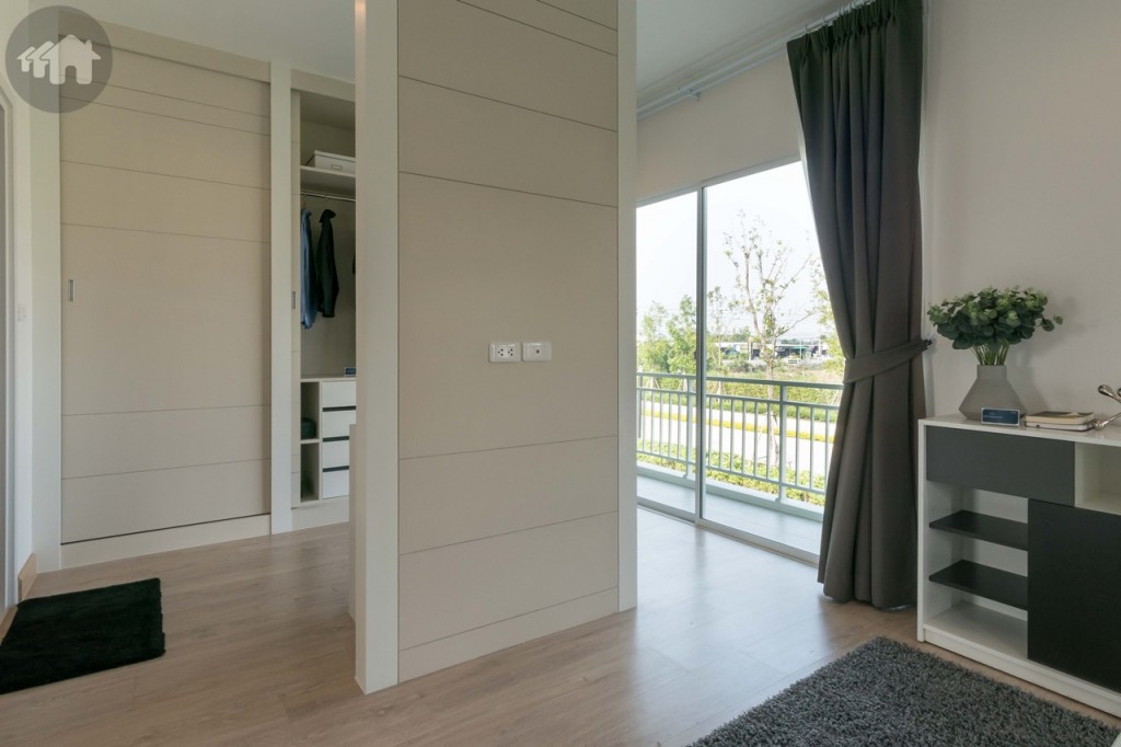 พื้นที่ปลายเตียงขนาดใหญ่ ตกแต่งเป็น Walk-in closet และเชื่อมต่อกับระเบียงด้วยประตูกระจกบานเลื่อนแบบ 2 ทาง ขนาดใหญ่