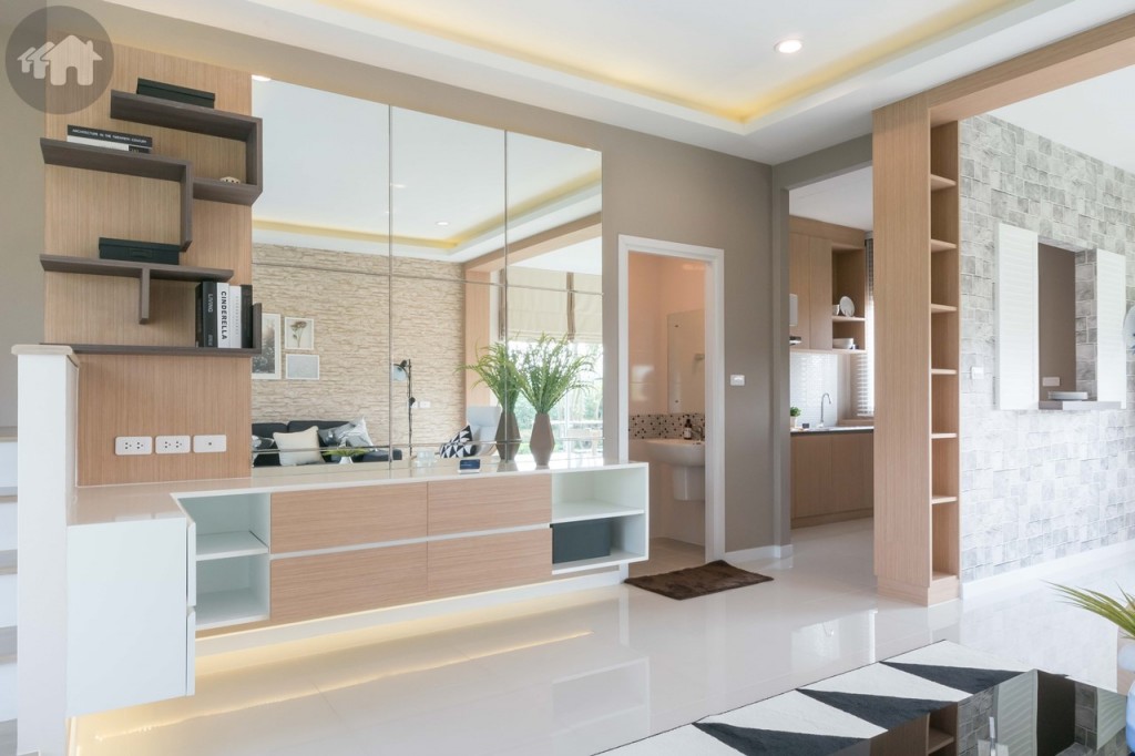 ฝั่งตรงข้ามตกแต่งเป็นชั้นวางโทรทัศน์ ห่างจากโซฟาประมาณ 3.20 เมตร