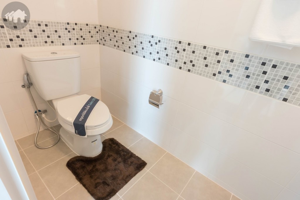 ห้องน้ำชั้นล่างอุปกรณ์ครบครัน ผนังปูกระเบื้องขนาด 40x25 เซนติเมตร พื้นปูกระเบื้องขนาด 30x30 เซนติเมตร