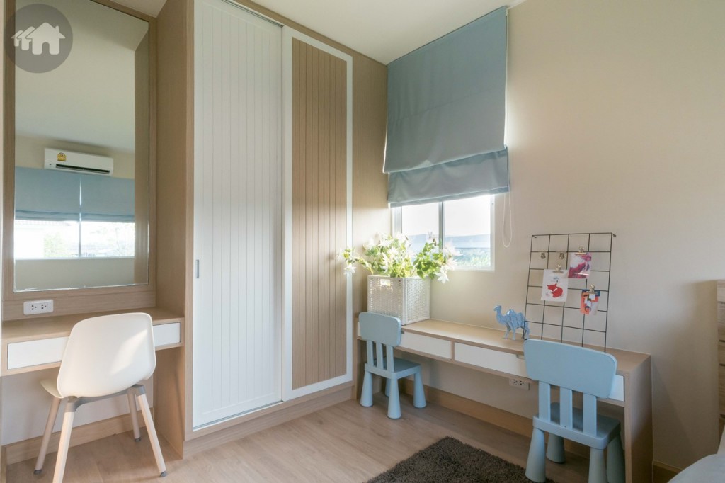 ข้างเตียงตกแต่งเป็นโต๊ะเขียนหนังสือ ตู้เสื้อผ้า และโต๊ะเครื่องแป้ง