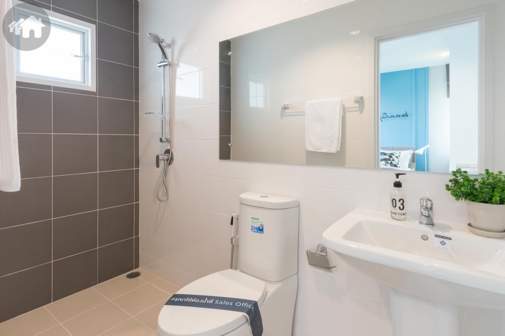 ห้องน้ำขนาดใหญ่อุปกรณ์ครบครัน ดร็อปจากพื้นห้องประมาณ 3 เซนติเมตร พื้นที่อาบน้ำมีขอบกั้นน้ำไหลมาส่วนอื่นของห้องน้ำสูงประมาณ 5 เซนติเมตร พื้นปูกระเบื้องขนาด 30x30 เซนติเมตร ผนังปูกระเบื้องขนาด 40x25 เซนติเมตร ผนังพื้นที่อาบน้ำปูกระเบื้องขนาด 30x30 เซนติเมตร