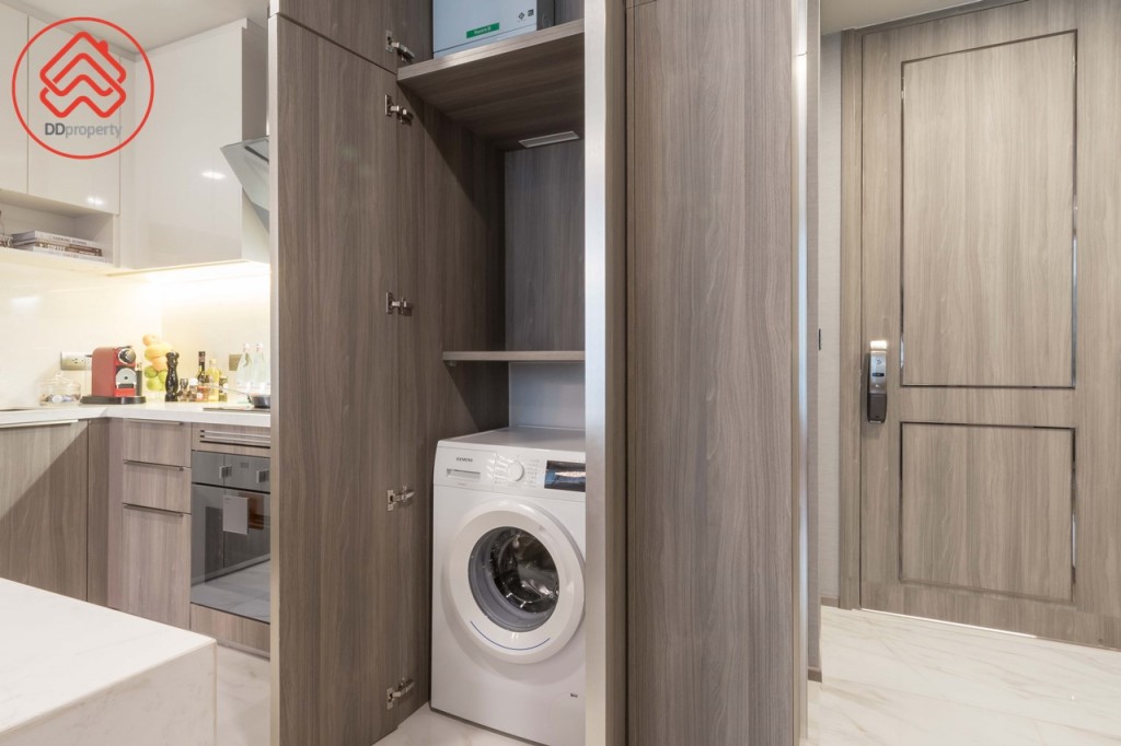 ใกล้กันเป็นตู้เก็บของและวางเครื่องซักผ้าบิลท์อิน สูงจรดเพดานเช่นกัน