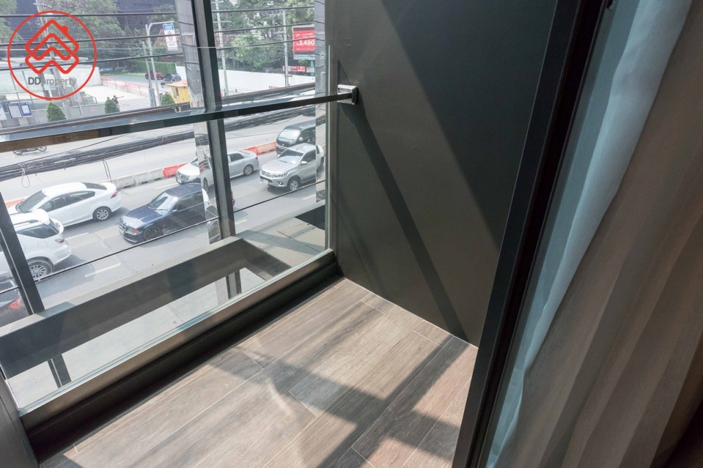 อีกด้านห่างจากข้างเตียงประมาณ 30 เซนติเมตร เชื่อมต่อกับระเบียงด้วยประตูกระจกบานเลื่อนแบบ 3 ตอน ขอบประตูยกสูงประมาณ 3 เซนติเมตร ระเบียงกว้างประมาณ 1 เมตร ยาวประมาณ 1.40 เมตร รั้วสูงประมาณ 1.20 เมตร 