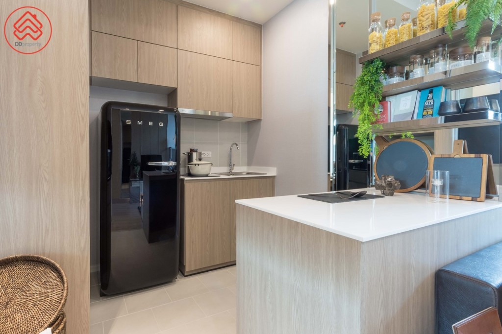 ห้องครัวมาพร้อมตู้ครัวบิลท์อินรูปตัวแอล ด้านข้างมีที่ว่างประมาณ 75 เซนติเมตร สำหรับวางตู้เย็น พิเศษด้วย Kitchen Island ทางเดินกว้างประมาณ 1.10 เมตร พื้นปูกระเบื้องขนาด 30x30 เซนติเมตร