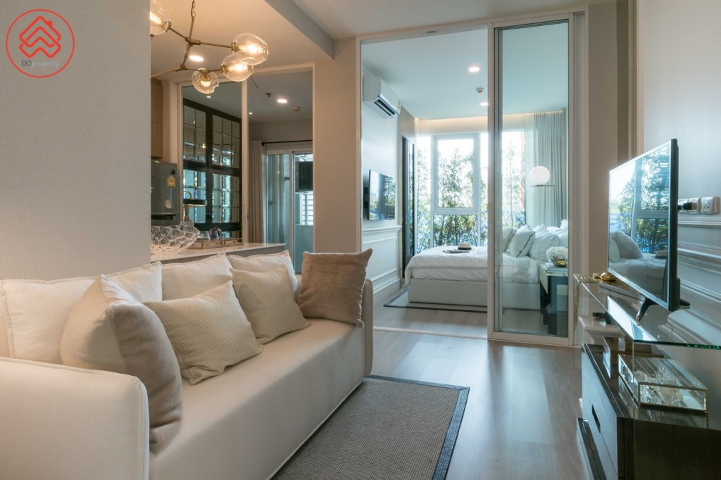 เข้ามาภายในห้องเป็นห้องนั่งเล่น เชื่อมต่อแบบ Open Space กับห้องครัว และกั้นเป็นสัดส่วนกับห้องนอน และห้องเอนกประสงค์ โปร่งโล่งด้วยเพดานสูงถึง 2.75 เมตร พื้นปูลามิเนตหนา 12 มิลลิเมตร