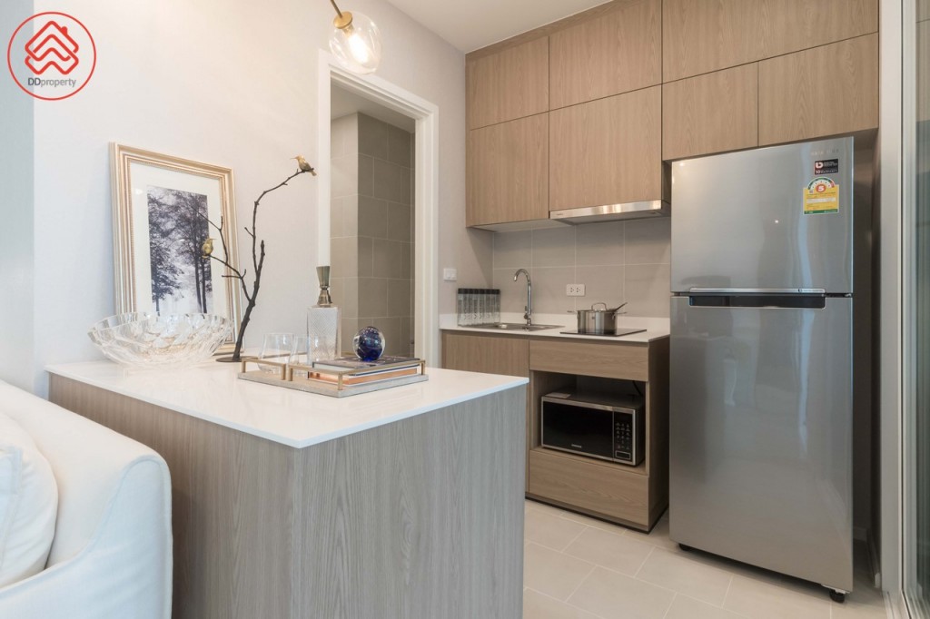 ห้องครัวมาพร้อมตู้ครัวบิลท์อินบน-ล่าง เตาไฟฟ้า เครื่องดูดควัน และอ่างล้างจานของ Hafele ด้านข้างมีที่ว่างประมาณ 85 เซนติเมตร สำหรับวางตู้เย็น ตัว Back Splash ปูกระเบื้องขนาด 30x30 เซนติเมตร ทางเดินกว้างประมาณ 1.10 เมตร พื้นปูกระเบื้องขนาด 30x30 เซนติเมตร พิเศษด้วย Kitchen Island