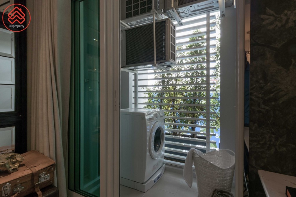 เชื่อมต่อกับระเบียงด้วยประตูกระจกบานเลื่อนแบบ 3 ตอน ขอบประตูยกสูงประมาณ 12 เซนติเมตร ระเบียงกว้างประมาณ 1.15 เมตร ยาวประมาณ 1.50 เมตร ออกแบบให้เป็น Private Balcony มีระแนงกั้นเพิ่มความสวยงามและเป็นระเบียบเมื่อมองจากภายนอก ติดตั้งคอมเพรสเซอร์เครื่องปรับอากาศ 3 ตัว สูงจากพื้นประมาณ 1.50 เมตร พื้นปูกระเบื้องขนาด 30x30 เซนติเมตร