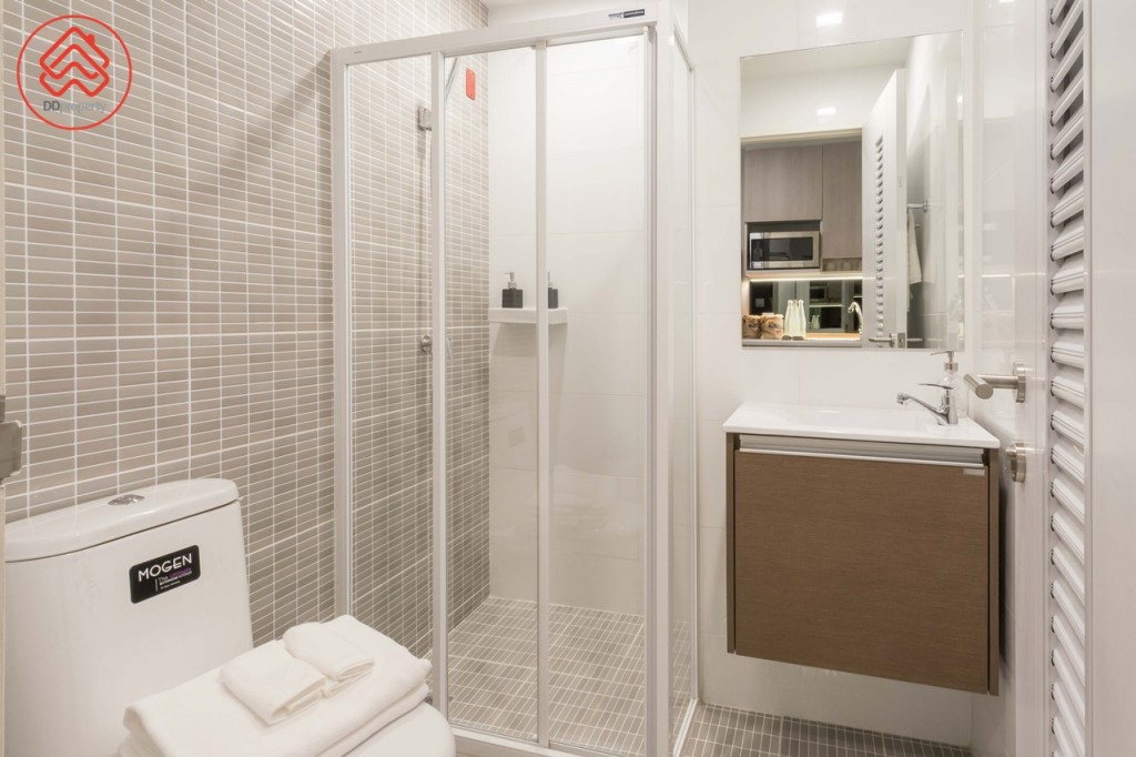 ตรงข้ามเป็นห้องน้ำอุปกรณ์ครบครัน พื้นห้องน้ำดร็อปจากพื้นห้องประมาณ 3 เซนติเมตร พื้นที่อาบน้ำกั้นเป็นสัดส่วนด้วยประตูกระจกบานเลื่อนแบบ 3 ตอน ขอบประตูยกสูงประมาณ 7 เซนติเมตร พื้นและผนังปูกระเบื้องขนาด 40x25 เซนติเมตร และขนาด 60x30 เซนติเมตร