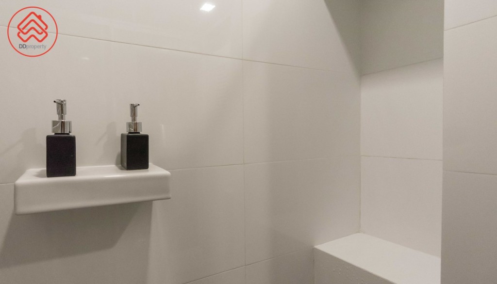 ด้านข้างตกแต่งเป็นแท่นและผนังเจาะเป็นช่องสำหรับวางอุปกรณ์อาบน้ำ