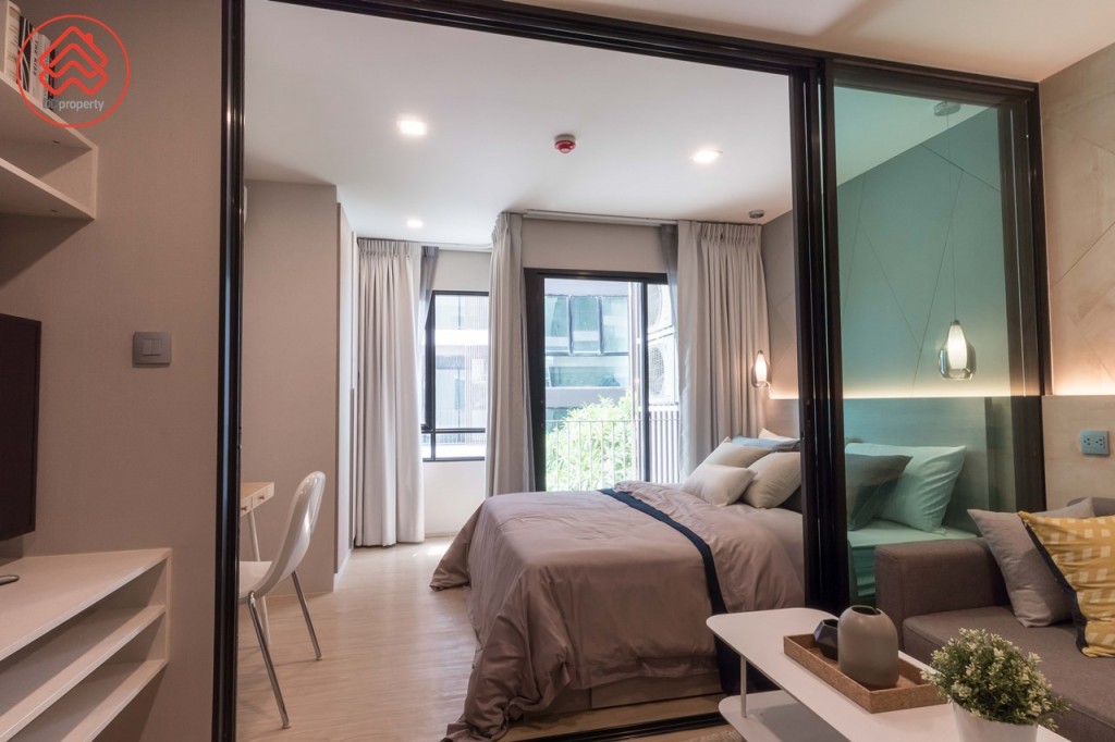 ห้องนั่งเล่นเชื่อมต่อกับห้องนอนด้วยประตูกระจกบานเลื่อนแบบ 3 ตอนบานใหญ่สูงจรดเพดาน