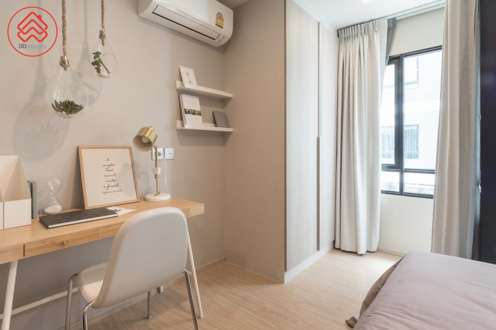 ปลายเตียงตกแต่งเป็นโต๊ะเขียนหนังสือ ด้านข้างเป็นตู้เสื้อผ้าบิลท์อินที่แถมมาให้กับห้อง ห่างจากปลายเตียงประมาณ 1.15 เมตร