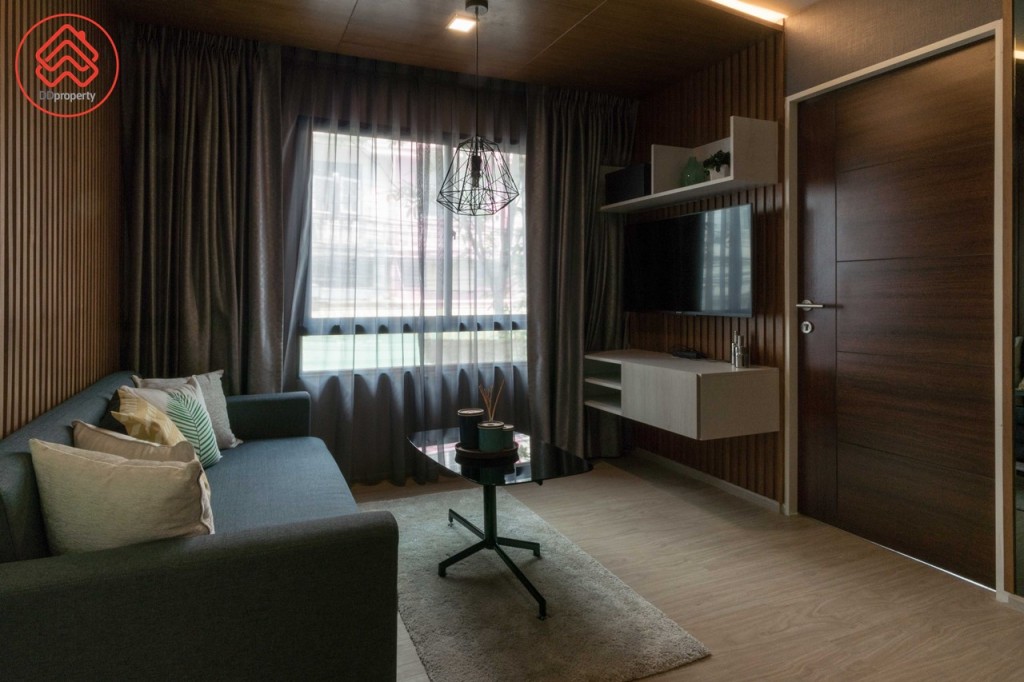 เชื่อมต่อกับห้องนั่งเล่นที่มาพร้อมโซฟาเบด โต๊ะกลาง และชั้นวางโทรทัศน์ ระยะดูโทรทัศน์กว้างประมาณ 1.60 เมตร เปิดรับวิวด้วยหน้าต่างกระจกบานเลื่อนแบบสลับ