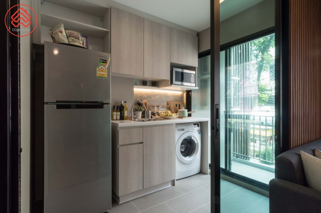 ห้องครัวกั้นเป็นสัดส่วนด้วยประตูกระจกบานเลื่อนแบบสลับ มาพร้อมตู้ครัวบิลท์อินบน-ล่าง ด้านบนมีที่วางเตาไมโครเวฟ ด้านล่างมีช่องสำหรับวางเครื่องซักผ้า อ่างล้างจานของ Techno ด้านข้างมีพื้นที่ว่างประมาณ 75 เซนติเมตร วางตู้เย็นขนาด 9.1 คิว ได้สบายๆ พื้นปูกระเบื้องขนาด 60x30 เซนติเมตร