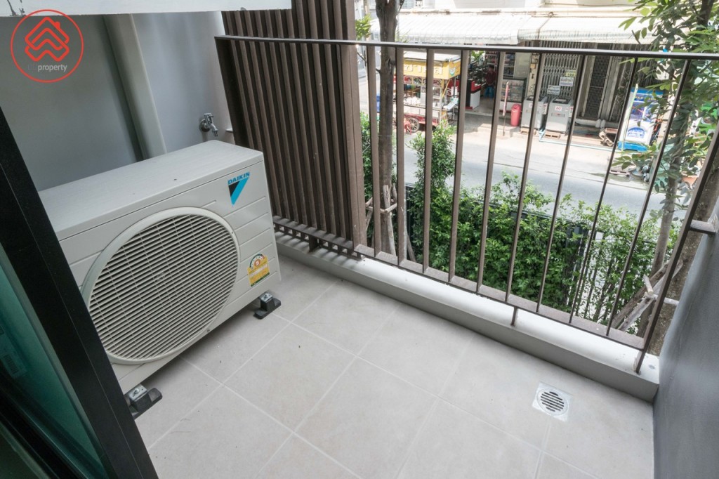 ระเบียงกั้นเป็นสัดส่วนด้วยประตูกระจกบานเลื่อนแบบสลับ ขอบประตูยกสูงประมาณ 10 เซนติเมตร ระเบียงกว้างประมาณ 90 เซนติเมตร ยาวประมาณ 1.80 เมตร รั้วสูงประมาณ 95 เซนติเมตร พื้นปูกระเบื้องขนาด 30x30 เซนติเมตร ด้านข้างติดตั้งคอมเพรสเซอร์เครื่องปรับอากาศ พร้อมระแนงกั้นเพื่อความสวยงาม ด้านล่างติดตั้งก๊อกน้ำ และท่อระบายน้ำให้เรียบร้อย