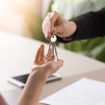 Woman getting keys to new rented own apartment, close up