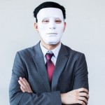 Property agent in a suit and wearing a white mask