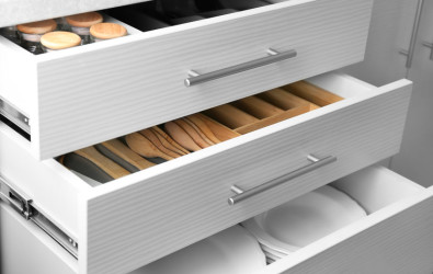 Set of ceramic plates and utensils in kitchen drawers