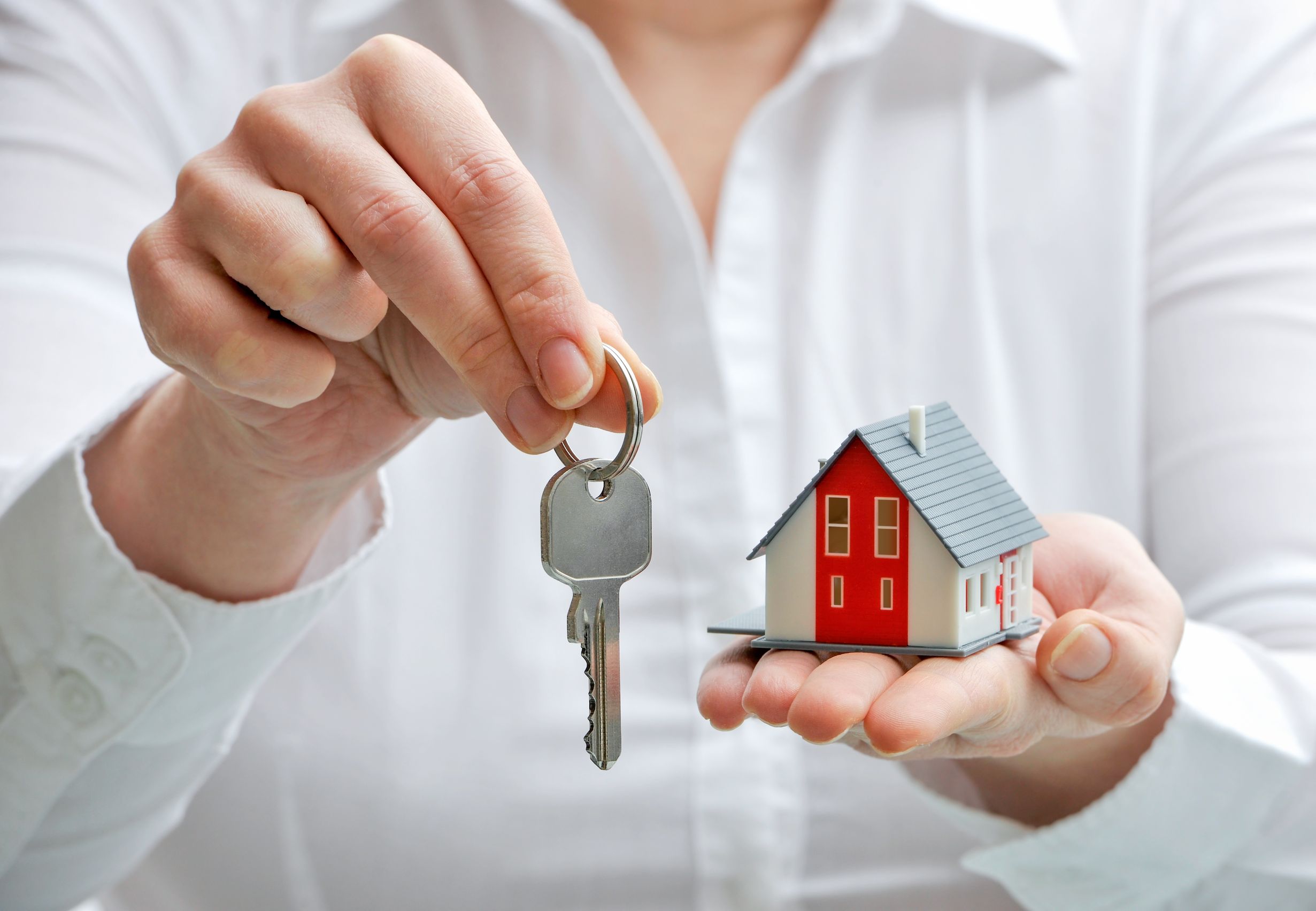 18148502 - real estBeli rumah di pameran properti menjadi ajang bagi banyak orang untuk mendapatkan hunian terbaiknya.ate agent with house model and keys