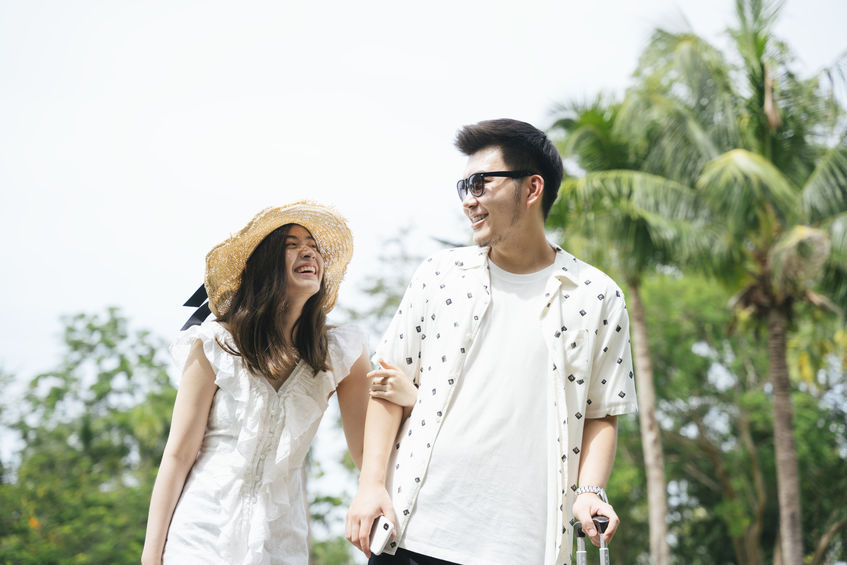 Couple traveler holding hands walking in the park outdoors.